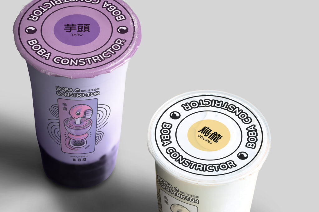 Boba Constrictor cups of taro and oolong milk tea. Their respective flavor illustrations are printed onto the side of the clear plastic cups, and the lids are different colors according to the flavors.